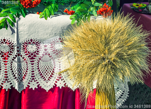 Image of A sheaf of wheat on a background of lace fabric.