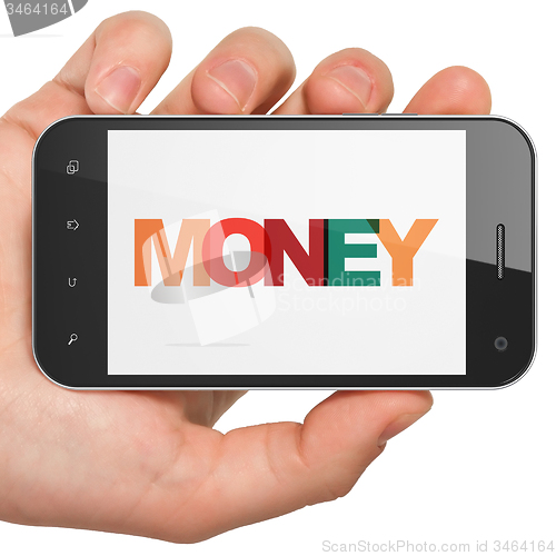 Image of Currency concept: Hand Holding Smartphone with Money on  display