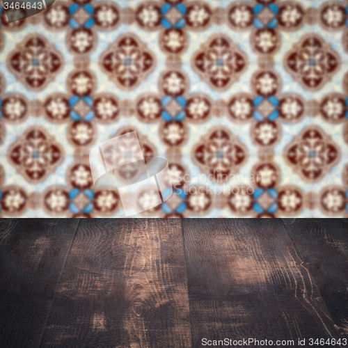 Image of Wood table top and blur vintage ceramic tile pattern wall
