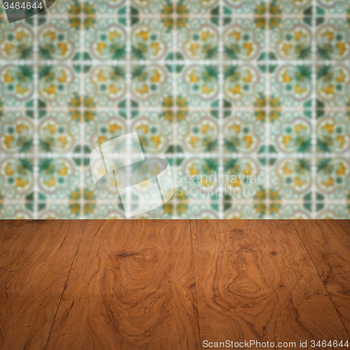Image of Wood table top and blur vintage ceramic tile pattern wall