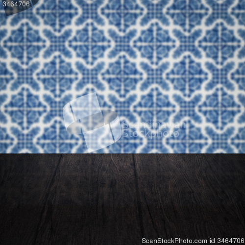 Image of Wood table top and blur vintage ceramic tile pattern wall