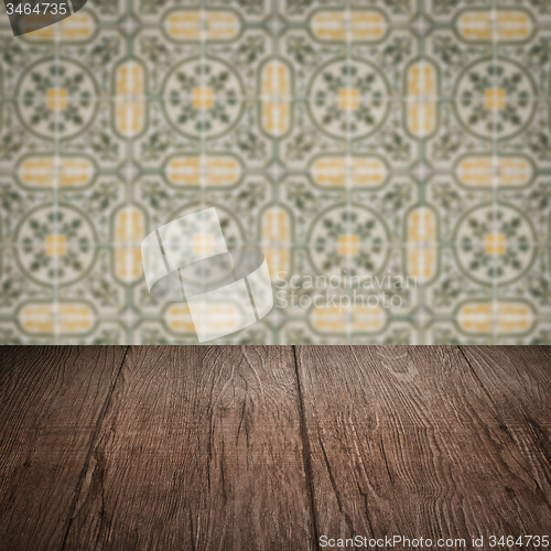 Image of Wood table top and blur vintage ceramic tile pattern wall