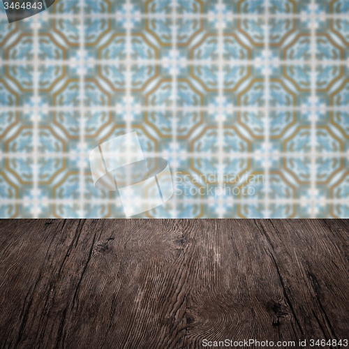 Image of Wood table top and blur vintage ceramic tile pattern wall