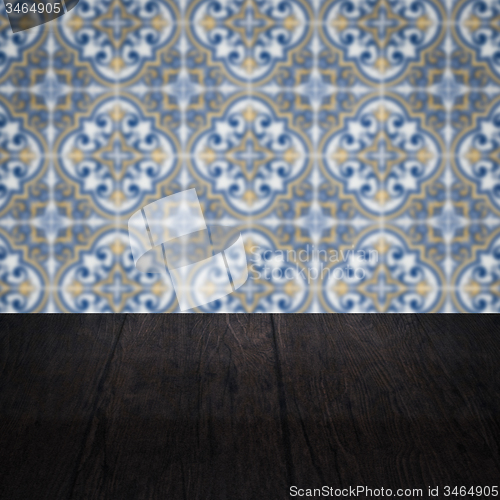 Image of Wood table top and blur vintage ceramic tile pattern wall
