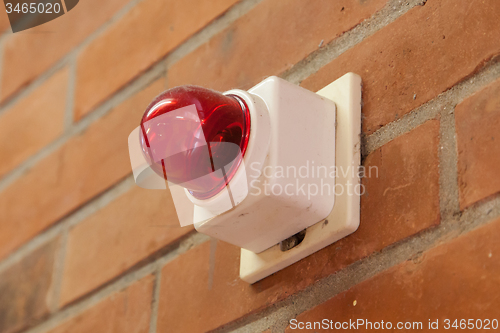 Image of Red emergency light on a brick wall