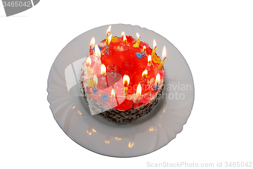 Image of birthday cake with lighted candles on plate