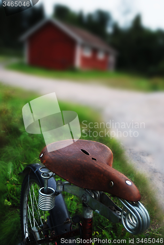 Image of vintage bicycle with the seat at a rural road