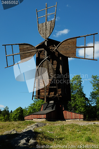 Image of ancient wooden windmill against the blue sky