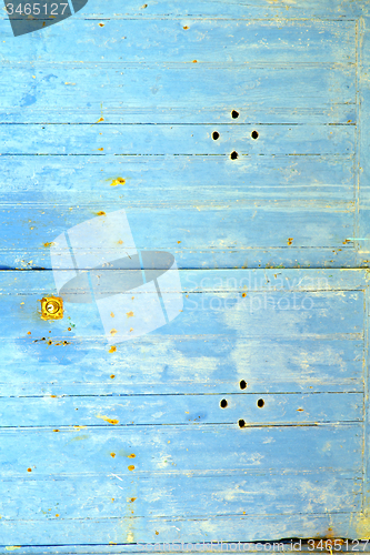 Image of stripped paint in  blue wood door  rusty nail