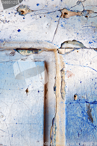 Image of stripped paint in   wood door and rusty nail