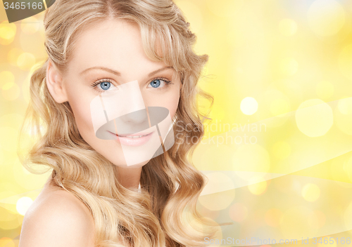 Image of beautiful young woman face over yellow lights