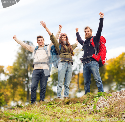 Image of group of smiling friends with backpacks hiking