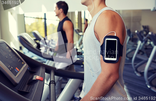 Image of close up of man with smartphone in gym