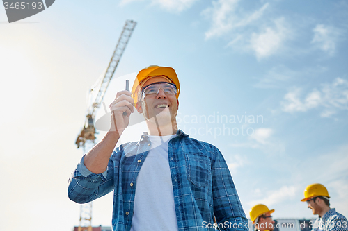 Image of builder in hardhat with walkie talkie