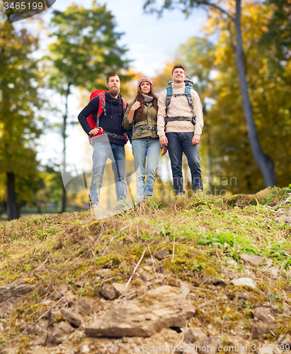 Image of group of smiling friends with backpacks hiking