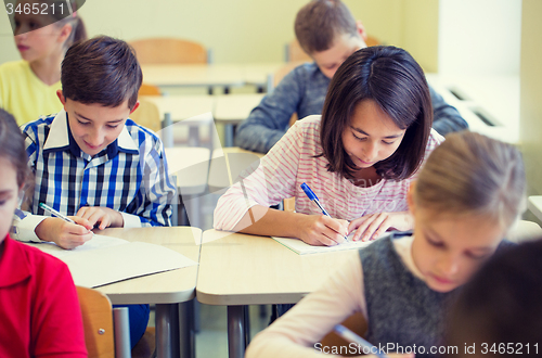 Image of group of school kids writing test in classroom