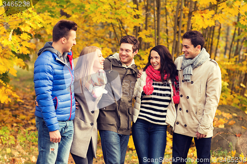 Image of group of smiling men and women in autumn park