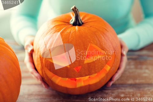 Image of close up of woman with pumpkins at home