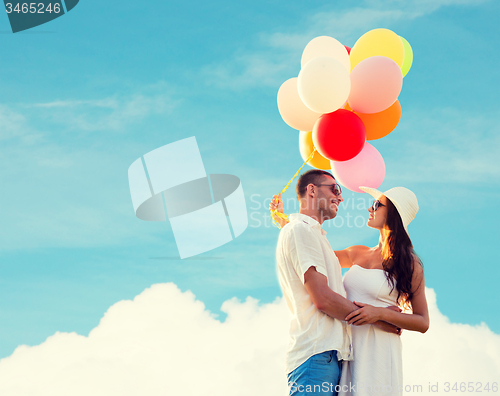 Image of smiling couple with air balloons outdoors