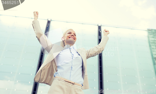 Image of young smiling businesswoman over office building