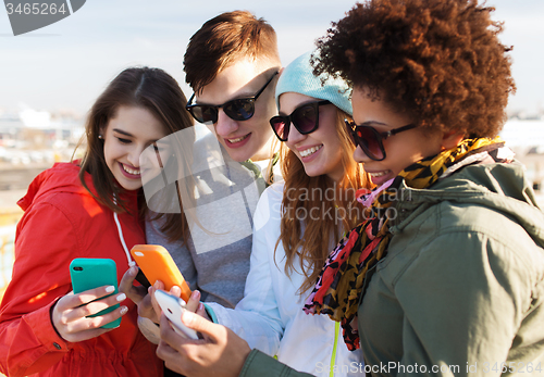 Image of smiling friends with smartphones