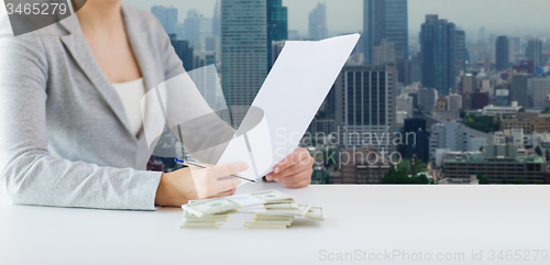 Image of close up of female hands with money and tax report