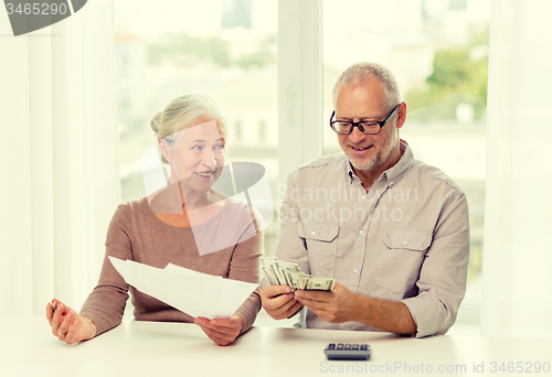 Image of senior couple with money and calculator at home