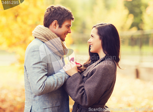 Image of close up of smiling couple with gift box in park