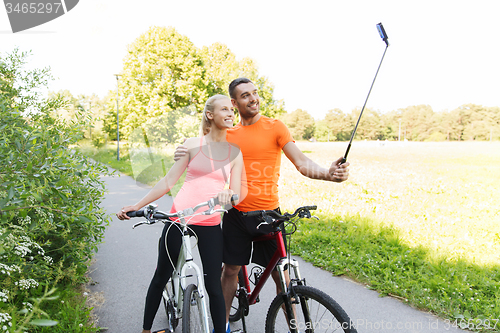 Image of couple with bicycle and smartphone selfie stick
