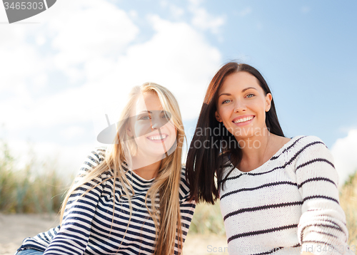 Image of happy teenage girls or young women on beach