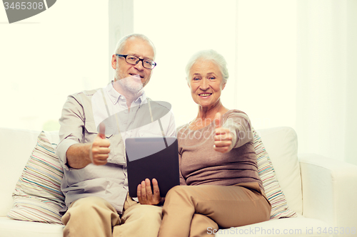Image of happy senior couple with tablet pc at home
