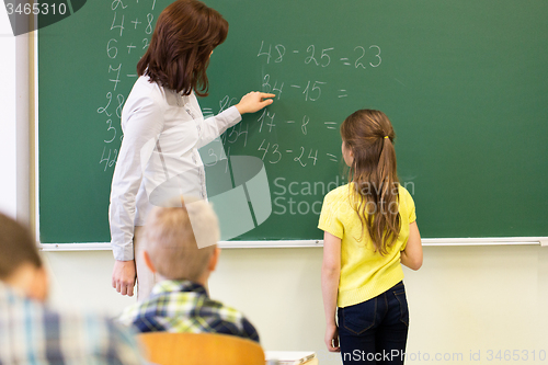 Image of schoolgirl and teacher with task on chalk board