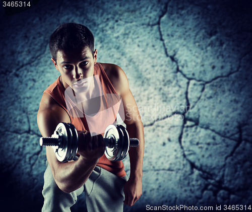 Image of young man with dumbbell flexing biceps