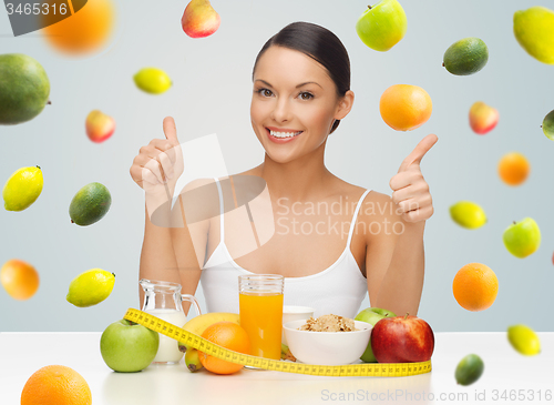 Image of happy woman with healthy food showing thumbs up