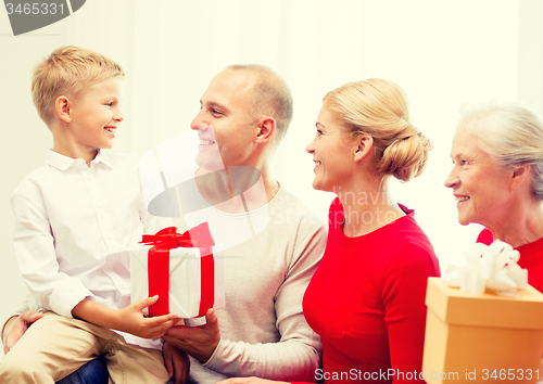 Image of smiling family with gifts at home