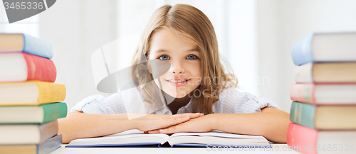 Image of smiling little student girl with many books