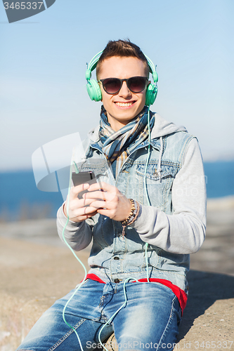 Image of happy young man in headphones with smartphone