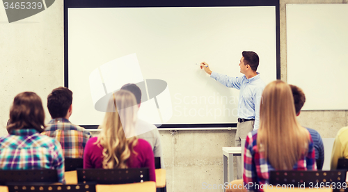 Image of group of students and smiling teacher in classroom