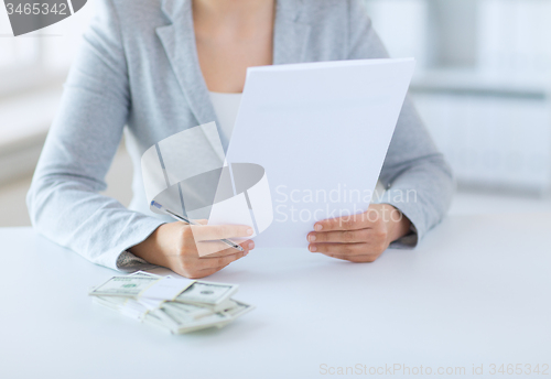 Image of close up of female hands with money and tax report