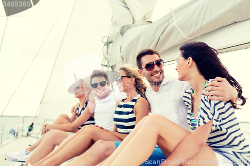 Image of smiling friends sitting on yacht deck