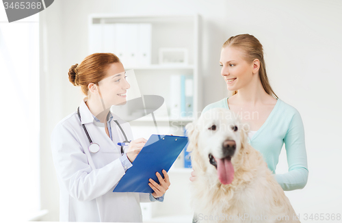 Image of happy doctor with retriever dog at vet clinic