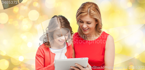 Image of mother and daughter with tablet pc over lights