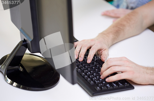 Image of close up of male hands with laptop typing