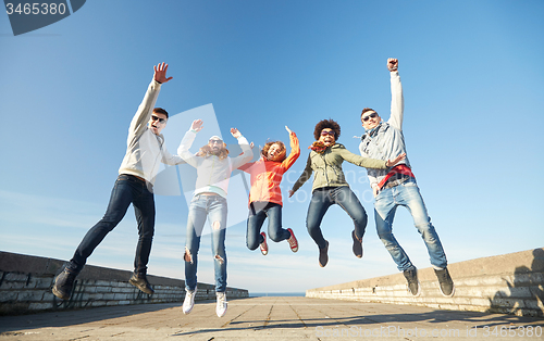 Image of smiling friends in sunglasses laughing on street