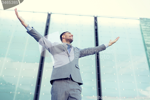 Image of young smiling businessman over office building