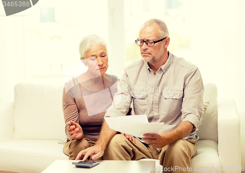 Image of senior couple with papers and calculator at home