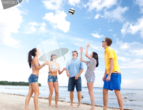 Image of group of happy friends playing beach ball