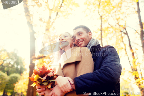 Image of smiling couple hugging in autumn park