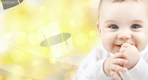 Image of close up of happy baby over yellow background