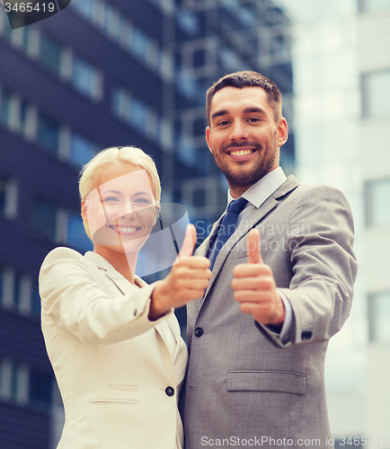 Image of smiling businessmen showing thumbs up